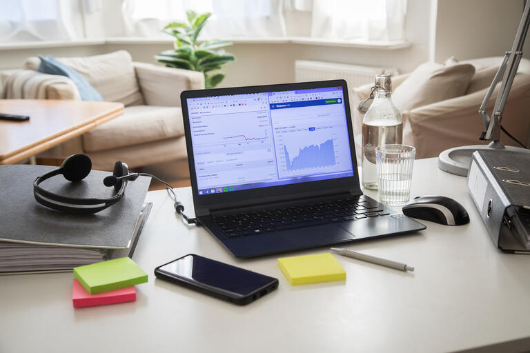  Eine Arbeitsecke mit Laptop, Headset und Ordnern wurde in einem Wohnzimmer eingerichtet,