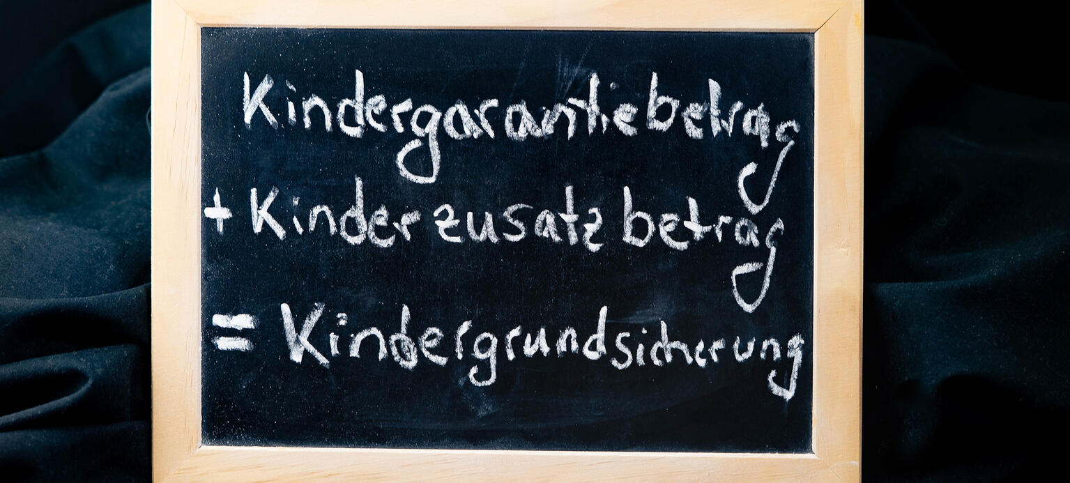 Kreidetafel mit der Schrift Kindergarantiebetrag und Kinderzusatzbetrag ist die Kindergrundsicherung