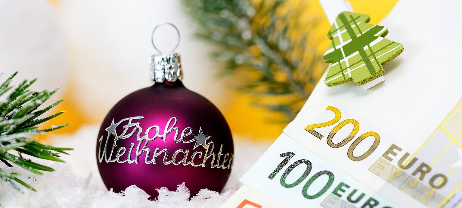 Weihnachtskugel mit Aufschrift Frohe Weihnachten und Geldscheine, Weihnachtsgeld