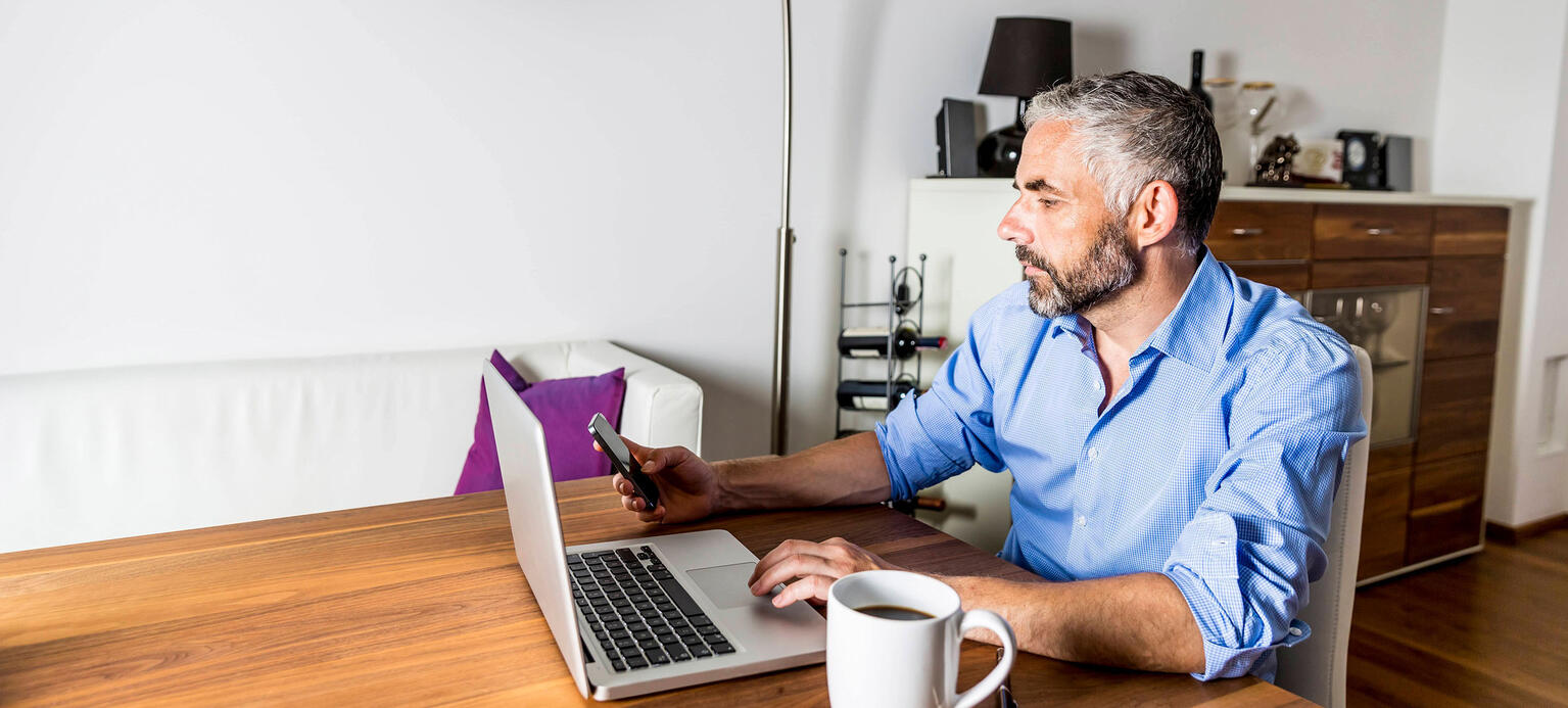 Portrait of businessman working with laptop at home office 