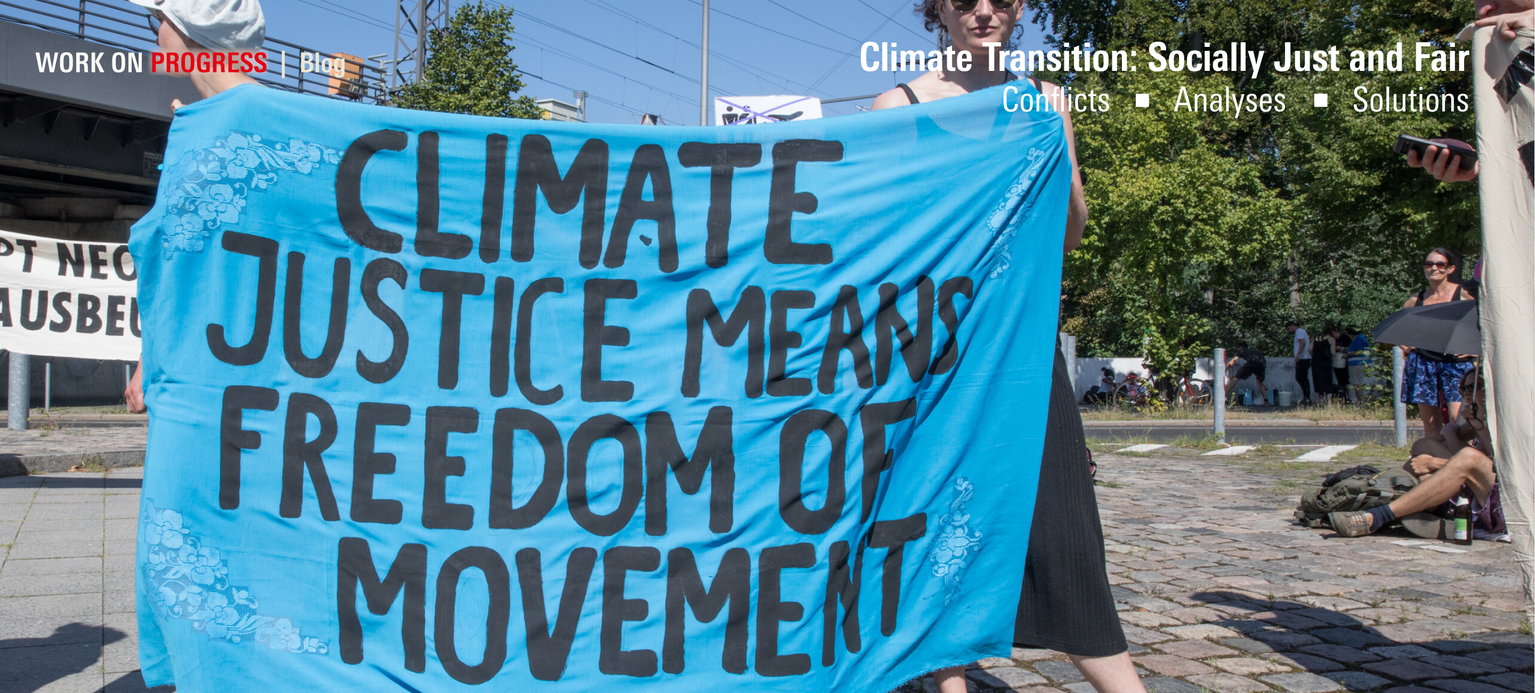 Protesters hold up a sign reading “Climate justice means freedom of movement.” 
